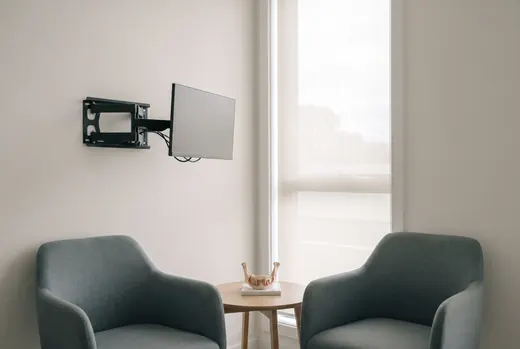 A quiet clinical consultation room with two chairs and an anatomical model of a mandible